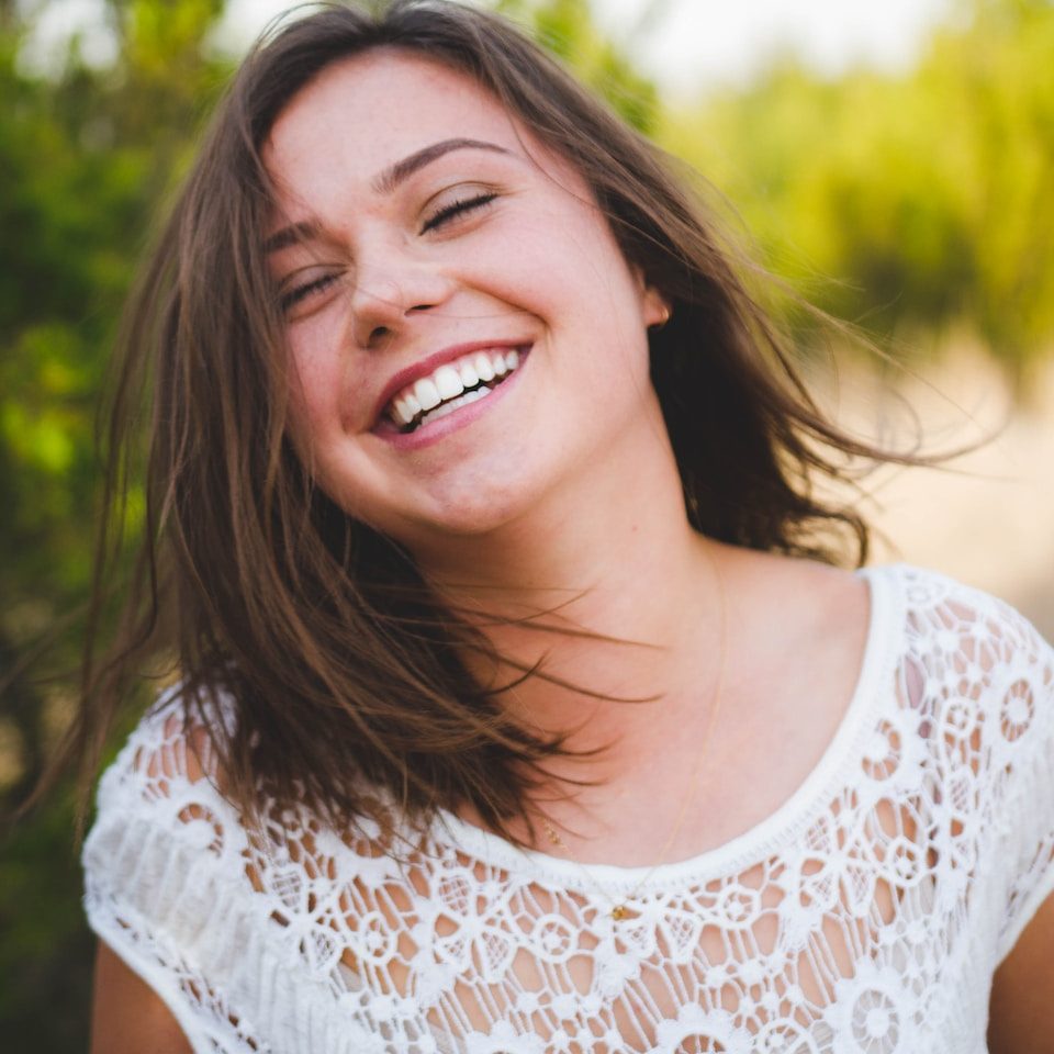 woman smiling wearing white top